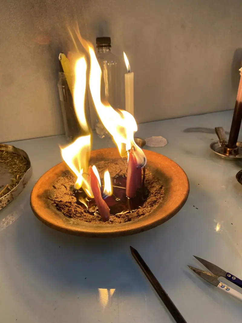 Fogo alto numa bacia de barro com velas queimando dentro